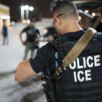 ICE agent seen from rear.